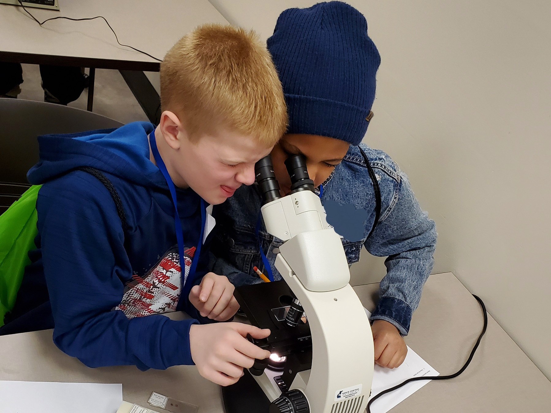 Two students looking into a mircoscope.