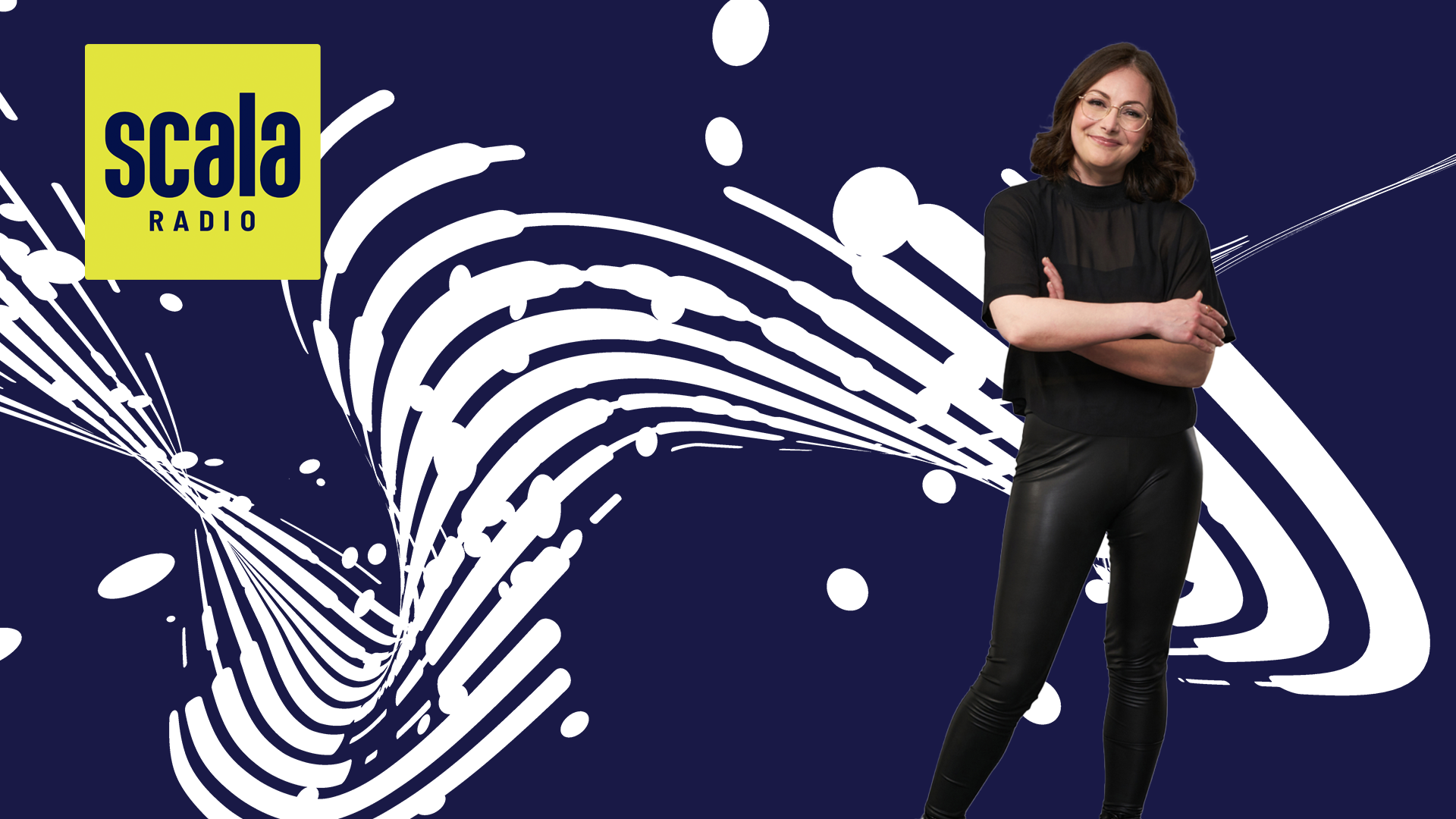 woman stands smiling with her arms folded