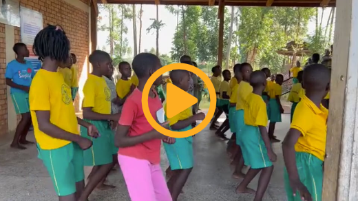 Mustard Seed Primary School kids dancing - dressed in yellow teeshirts and gym shorts.